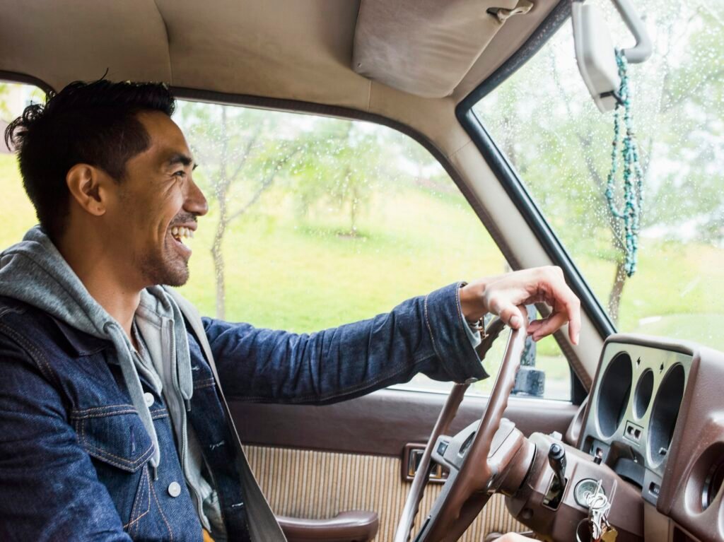 Young man in a car behind the steering wheel, driving.